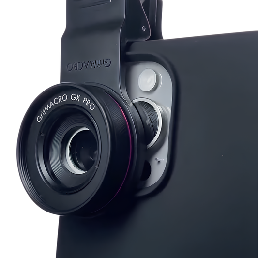 Primo piano angolato della lente macro GritMACRO GX PRO agganciata a uno smartphone, con un anello di filtro magenta distintivo per la fotografia macro di bellezza dettagliata.
