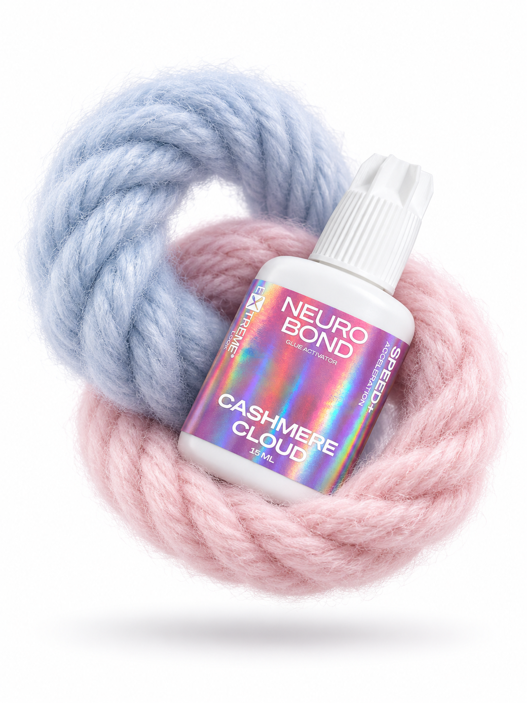 Composizione creativa e fluttuante con il flacone di acceleratore Extreme Look Neuro Bond avvolto da morbidi anelli di lana azzurra e rosa. L'alleato perfetto per mantenere un ritmo di lavoro elevato in cabina.