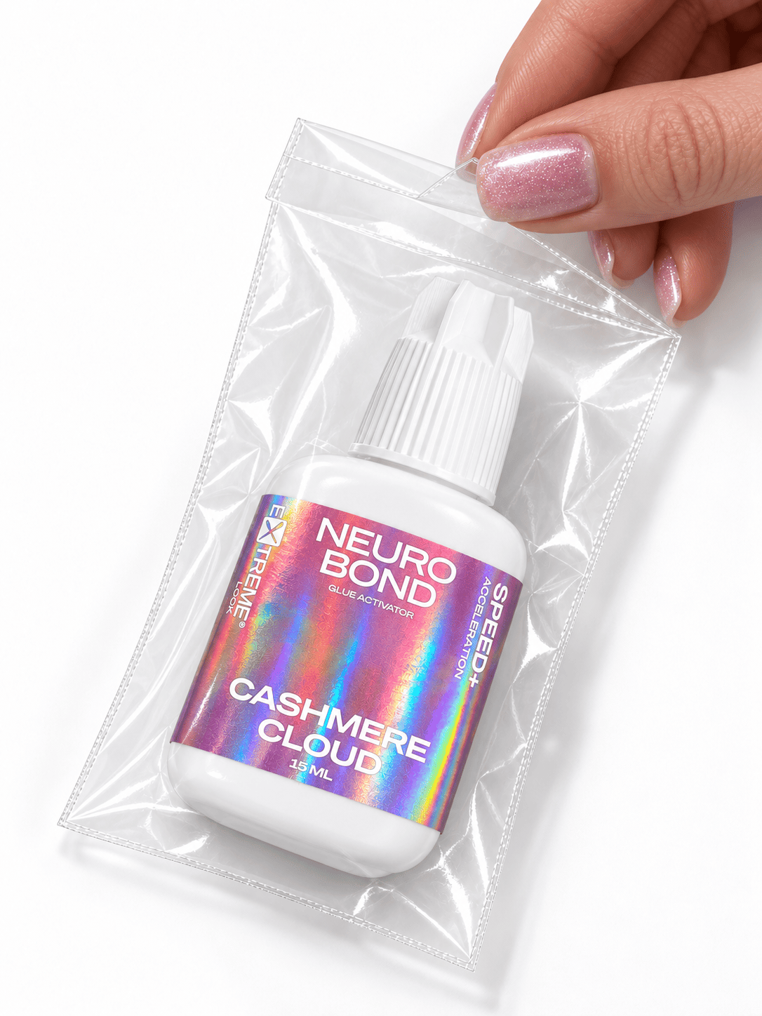 Flacone di acceleratore Extreme Look Neuro Bond Cashmere Cloud (15 ml) sigillato all'interno di una pratica bustina trasparente protettiva con chiusura a zip, tenuta tra le dita da una mano.