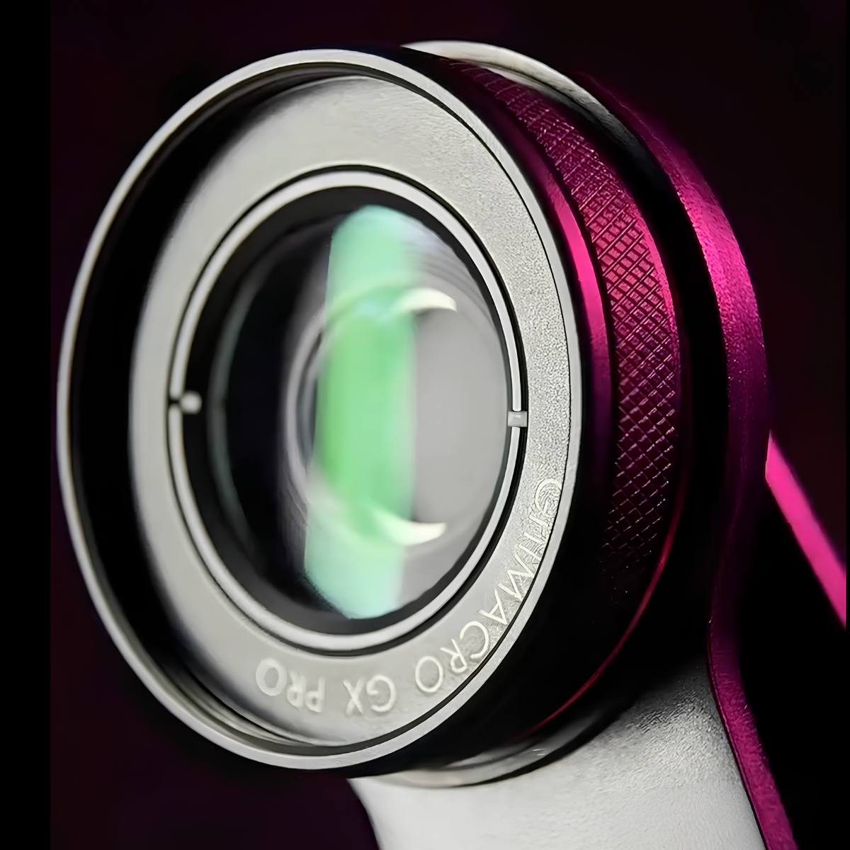 Primo piano della lente macro GritMACRO GX PRO che mostra le ottiche dettagliate, la struttura di attacco bianca e l'anello di filtro magenta-texture, contro uno sfondo scuro, evidenziando il sistema di lenti e filtri multi-elemento.